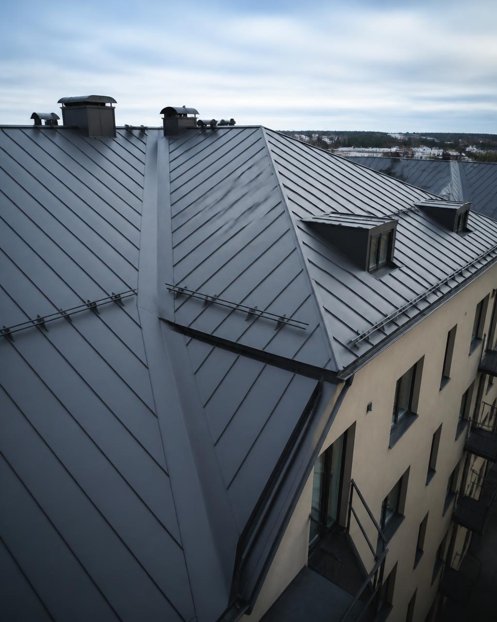Nylagt bandtäckt plåttak med takkupor på flerbostadshus